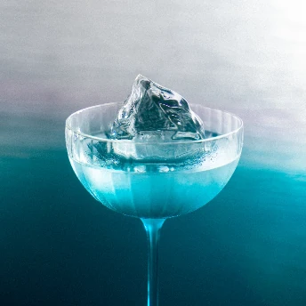 Cocktail bleu rafraîchi par un glaçon transparent