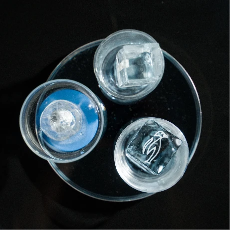 Différents formats de glaçons transparents présentés dans des verres